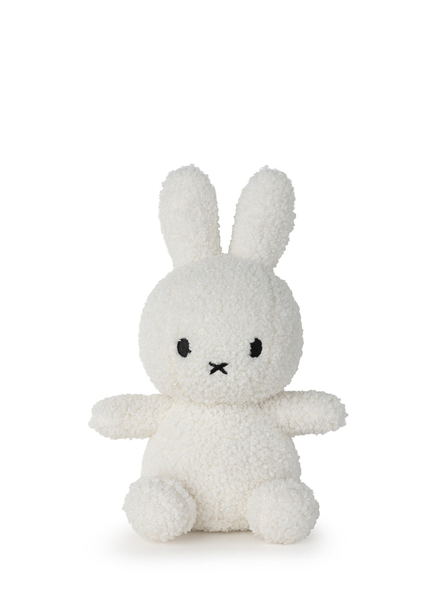 A small plush toy resembling a rabbit, made from recycled cream-colored fabric, seated against a plain background.