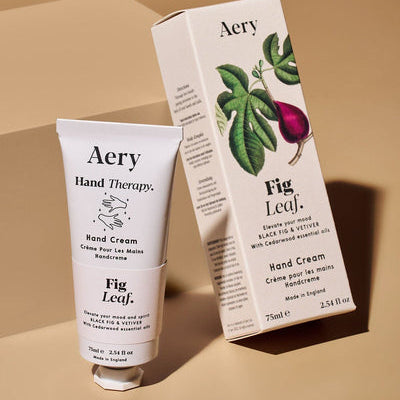 Aery Fig Leaf hand cream packaging and tube, featuring a leaf illustration and product information.