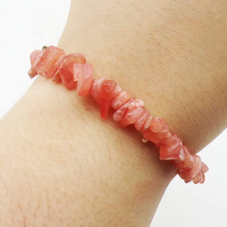 Rhodochrosite chip bracelet made from natural irregular stone pieces on an elasticated band on a wrist