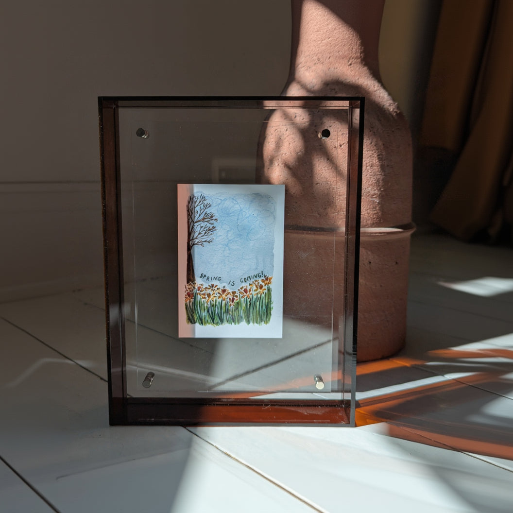 Framed artwork with a floral design on a white surface