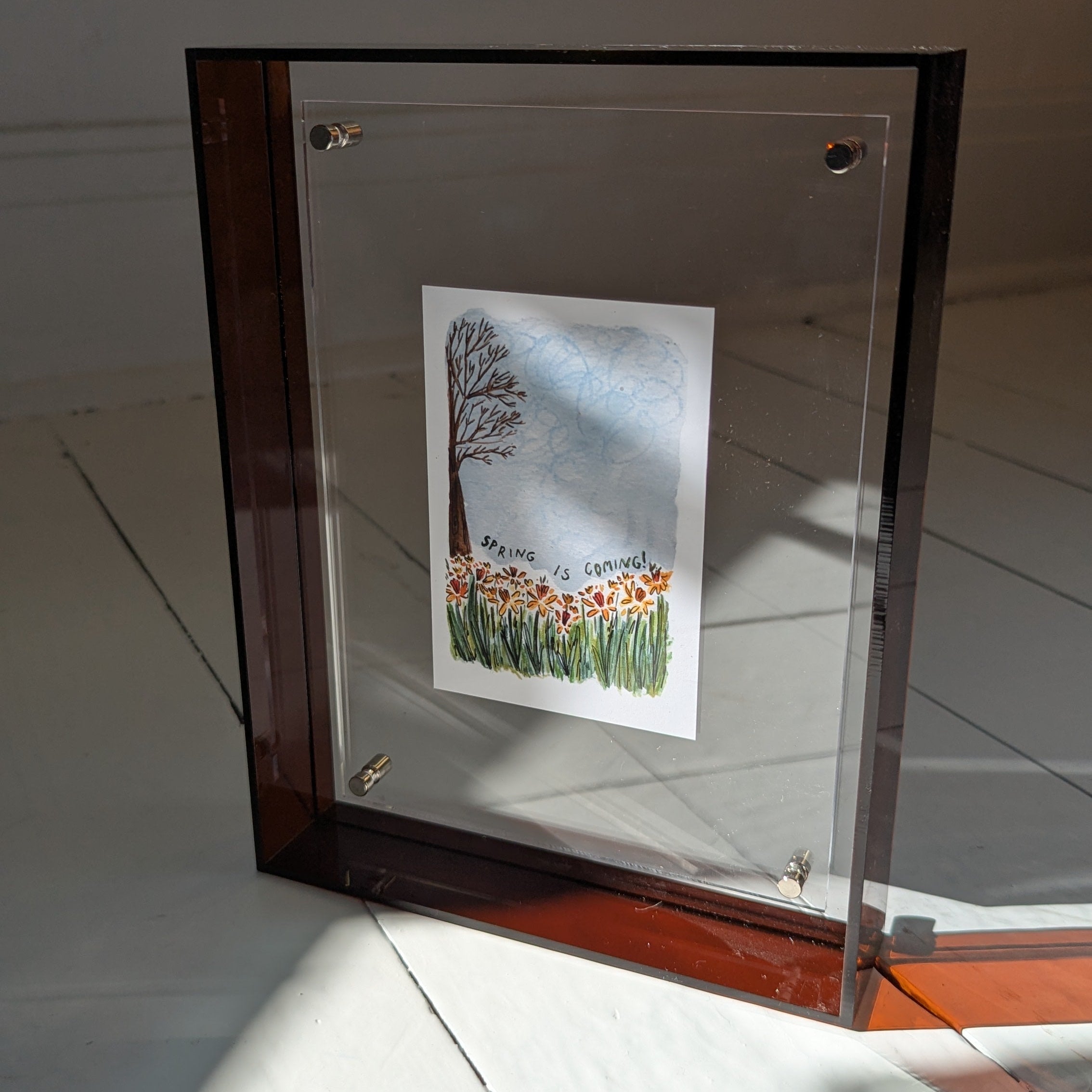 Framed artwork on a white surface with a neutral background